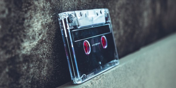 photo of a black cassette tape leaning against a wall.
